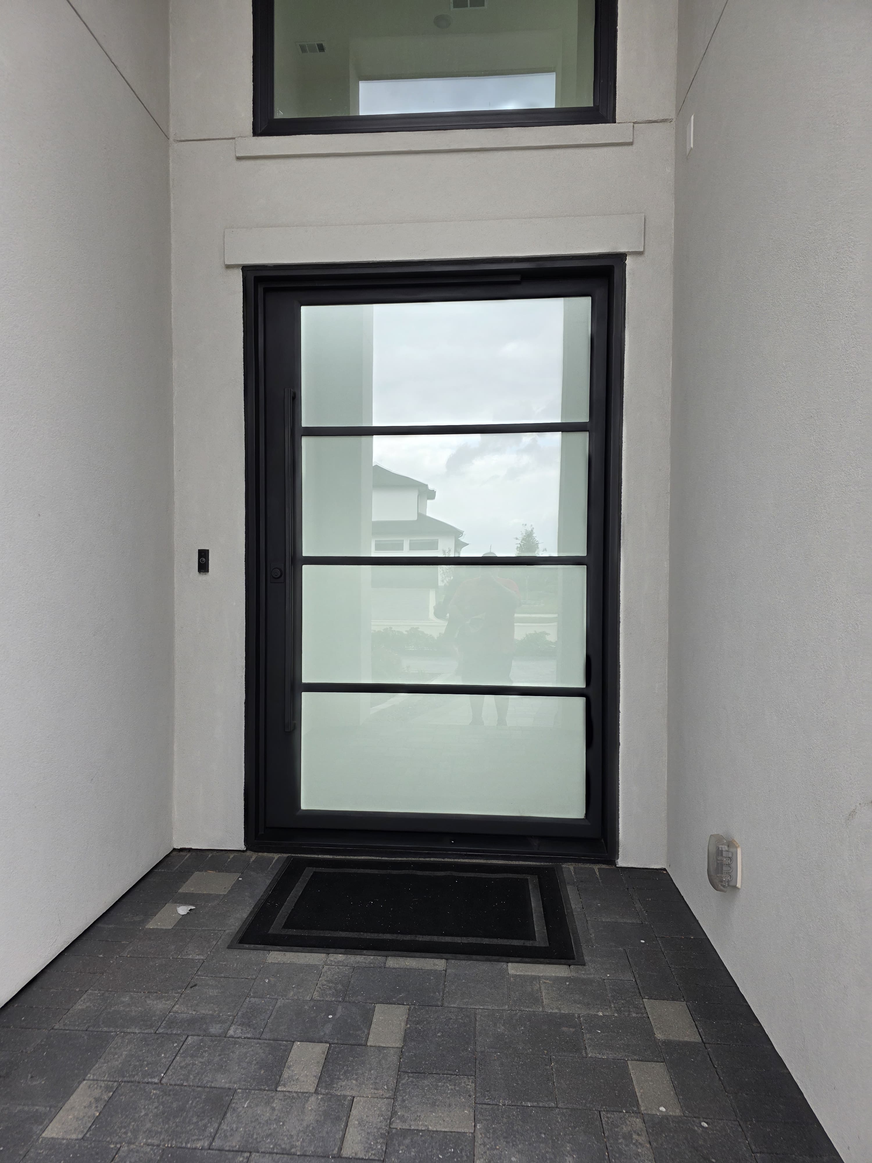 Modern iron pivot door with frosted glass panels