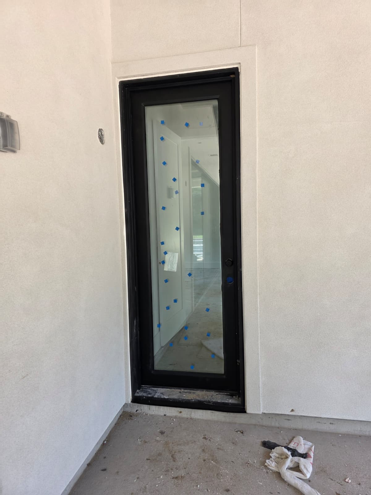 Custom black single iron entry door with full-height glass
