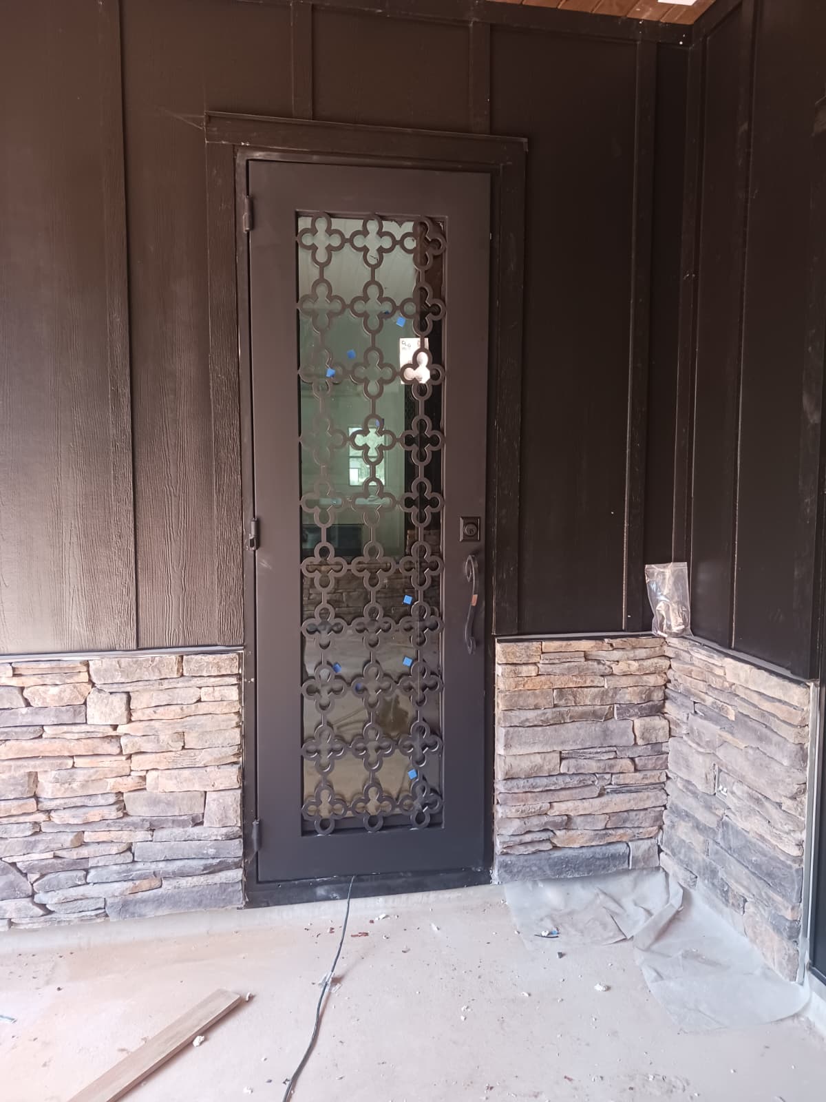 Black iron double entry doors with decorative geometric grilles