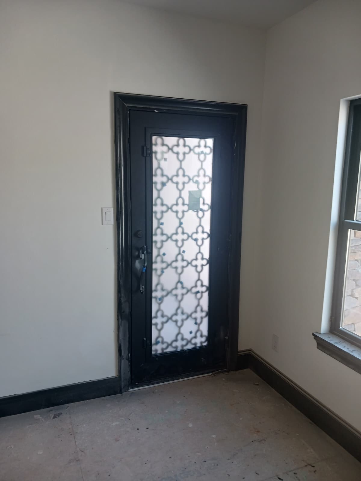 Interior view of an ornate iron entry door with grille detail