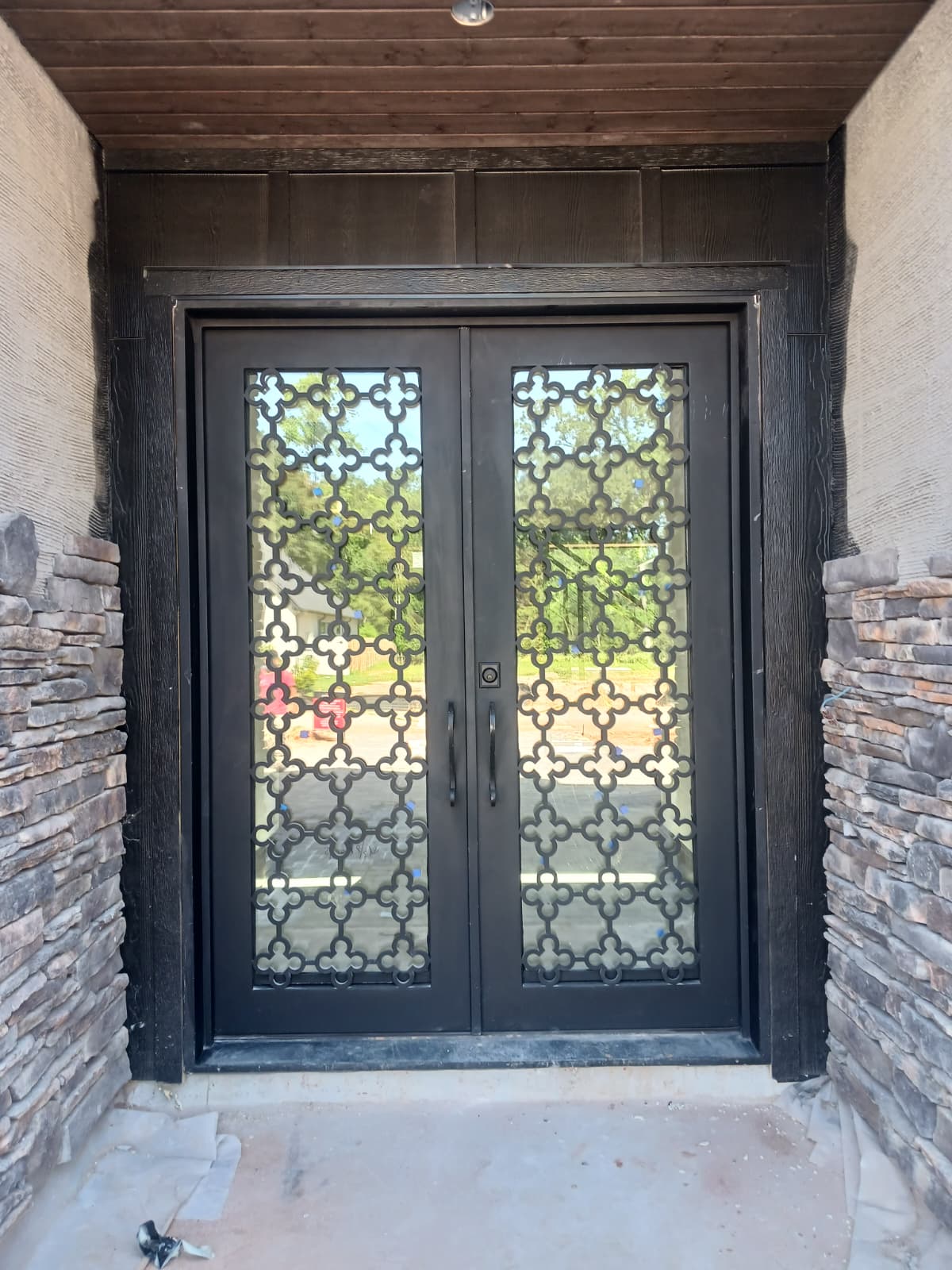 Black framed four-panel custom iron entry door
