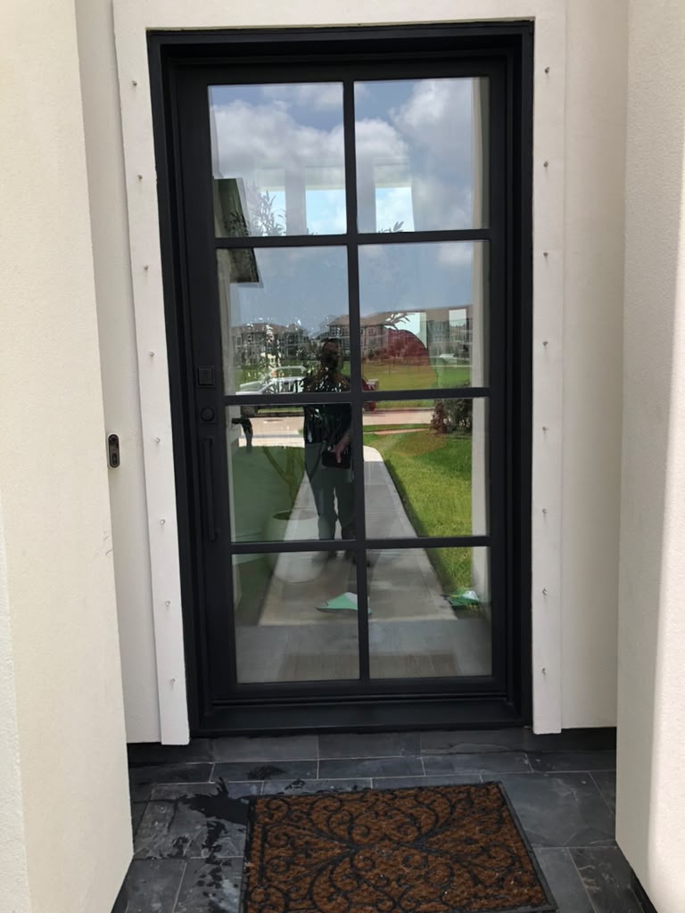 Black steel single entry door with a simple grid pattern